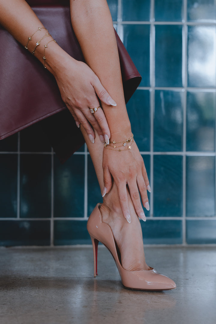 gold bracelet-delicate jewelry-woman's hands-nude high heels-fashion accessories- stylish pose-modern look
